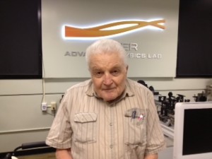 Male standing posing for picture in optics lab.