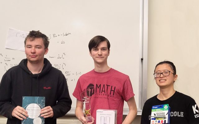 Eric, Daniel, and Tiffany standing in front of a white board with math equations holding their awards