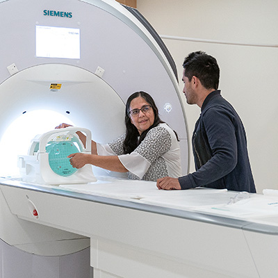 Usha Sinha shwoing student how to use MRI machine.