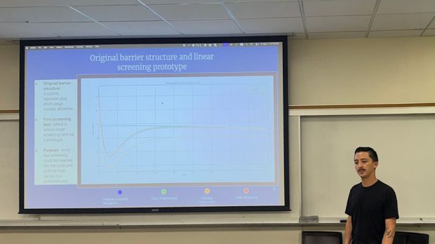 Student presenting a PowerPoint slide titled ‘Original barrier structure and linear screening prototype’ featuring a graph and screening model data in a classroom
